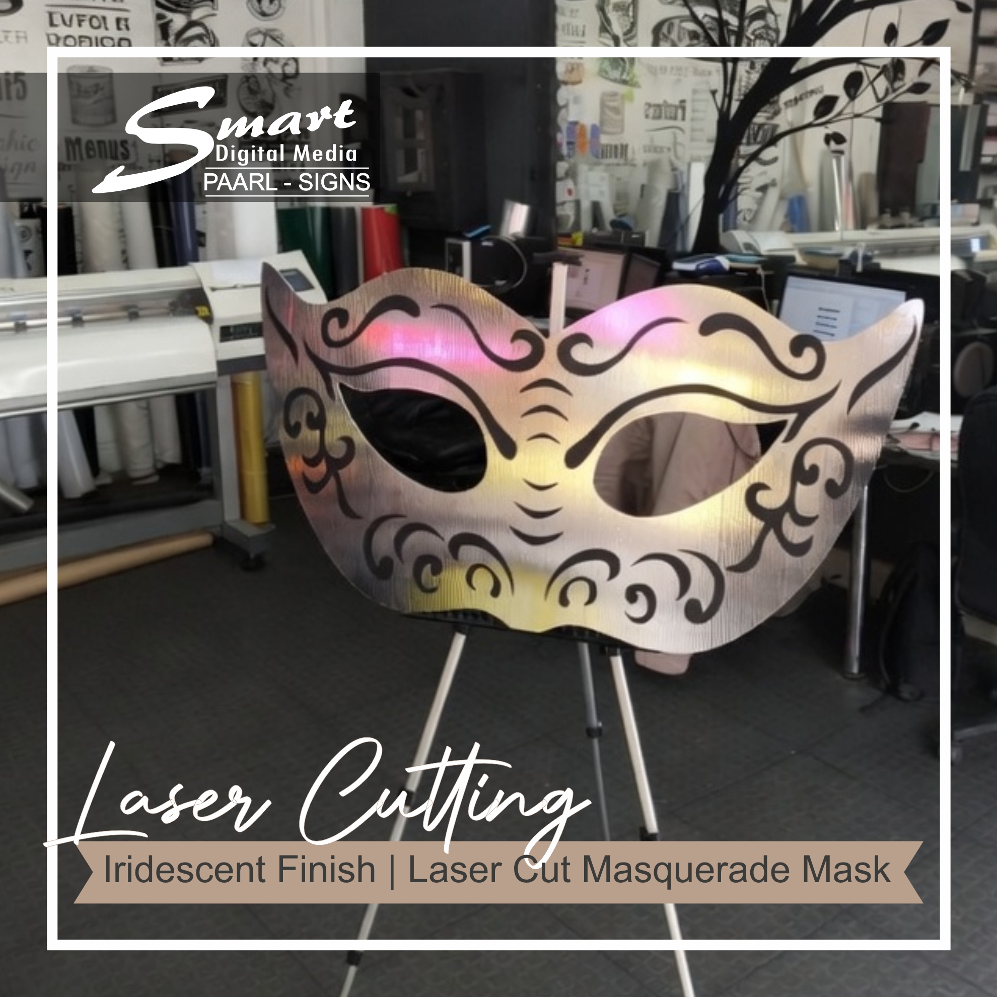 Holographic reflective laser-cut masquerade mask on tripod inside Smart Digital Media’s signage workshop for EventsByGray