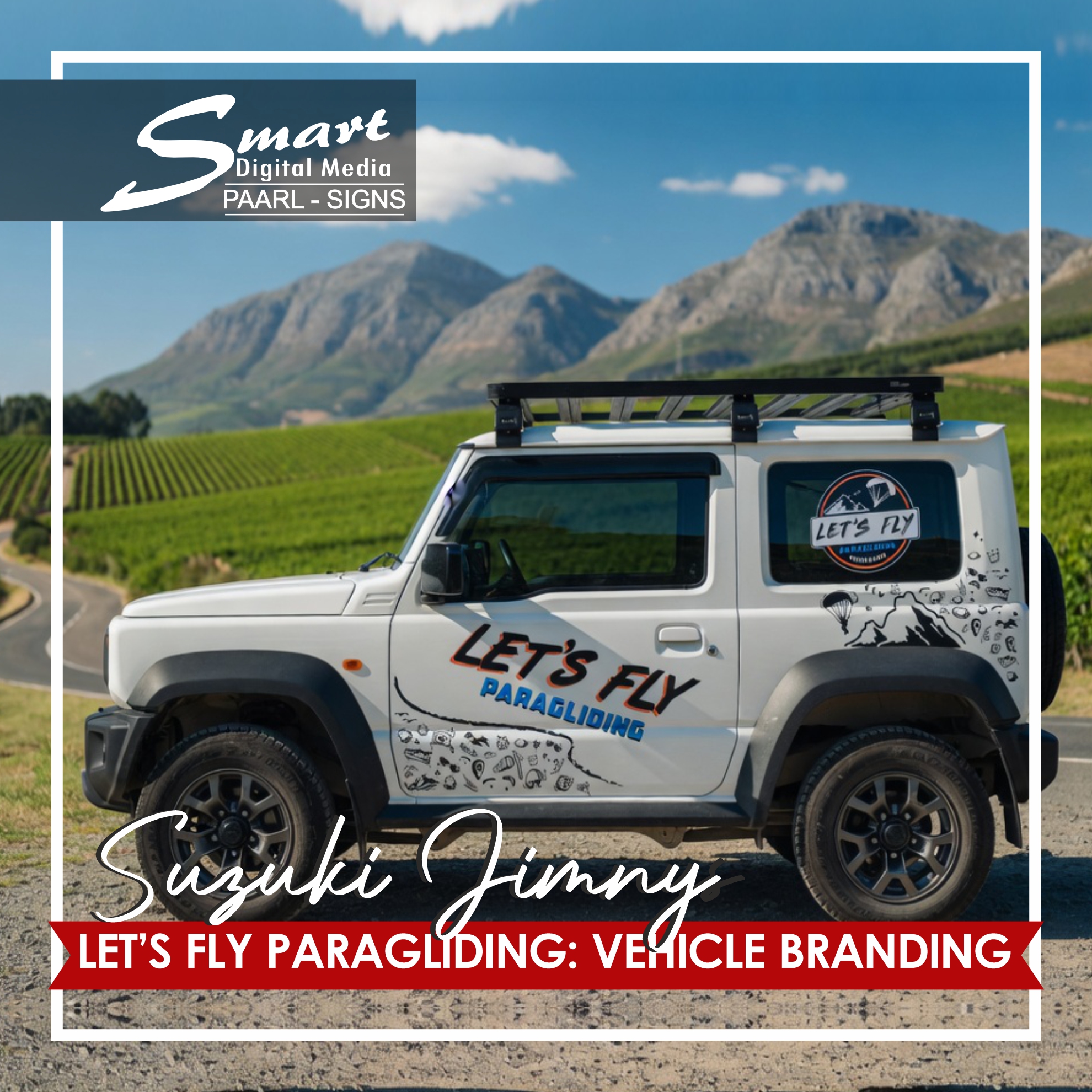 White Suzuki Jimny with vibrant "Let's Fly Paragliding" vinyl decals parked in stunning Cape Winelands vineyards with mountains in background, professional vehicle branding by Smart Digital Media's Signage Team